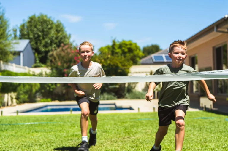 Two children running in a backyard with Sir Walter DNA Certified Buffalo Turf